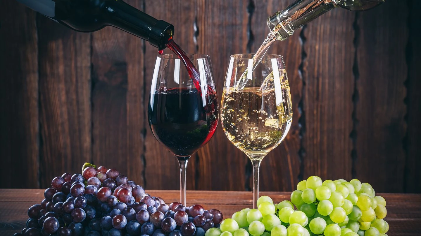 red and white wine poured into two glasses